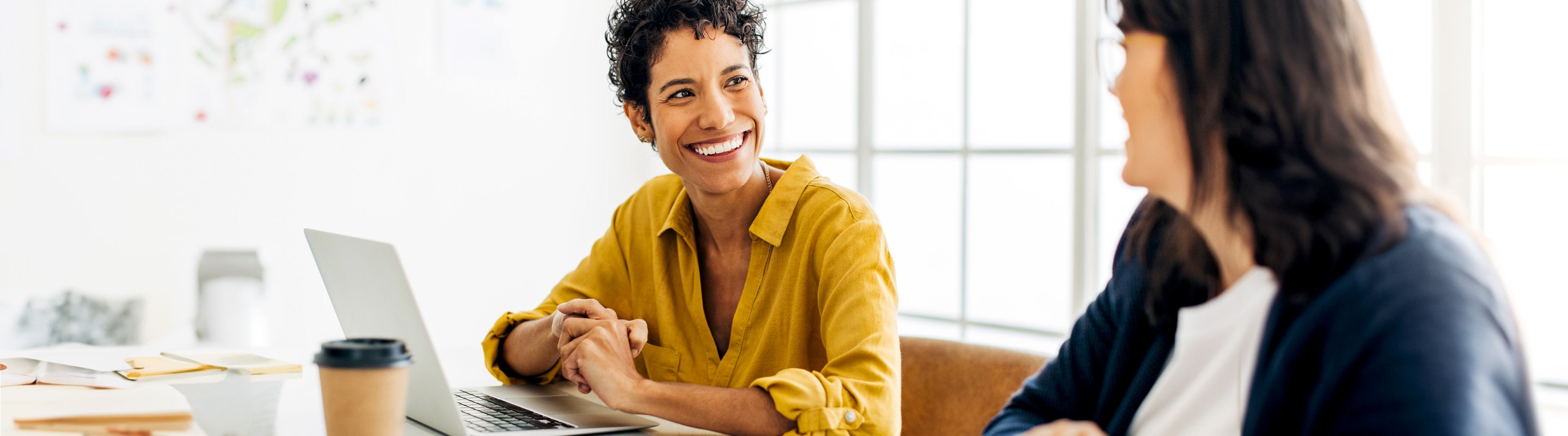 Two coworkers smiling while talking