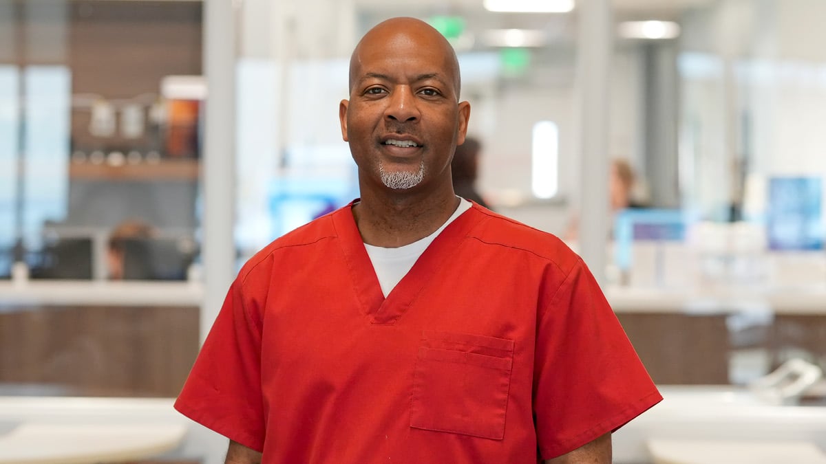 Rehabilitation hospital employee Randall Fannin recognized as OEAA South Central winner, pictured in red scrubs within a hospital environment representing clinical leadership and staff achievement.