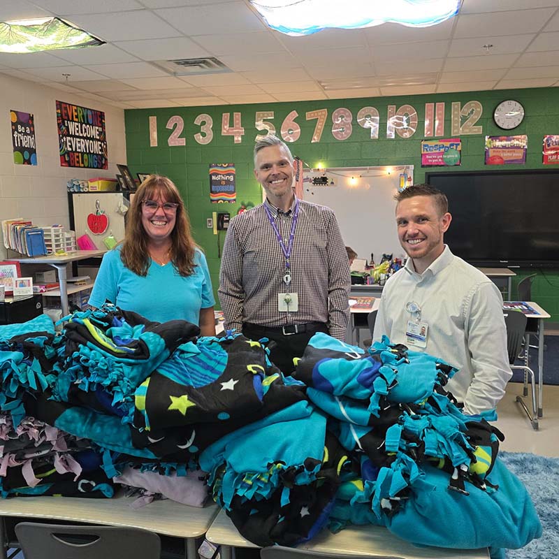 Encompass Health employees behind a pile of collected blankets