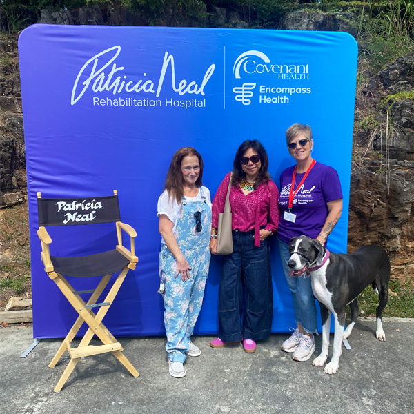 Patricia Neal staff posing with a service animal at a National Rehabilitation Awareness Week community event