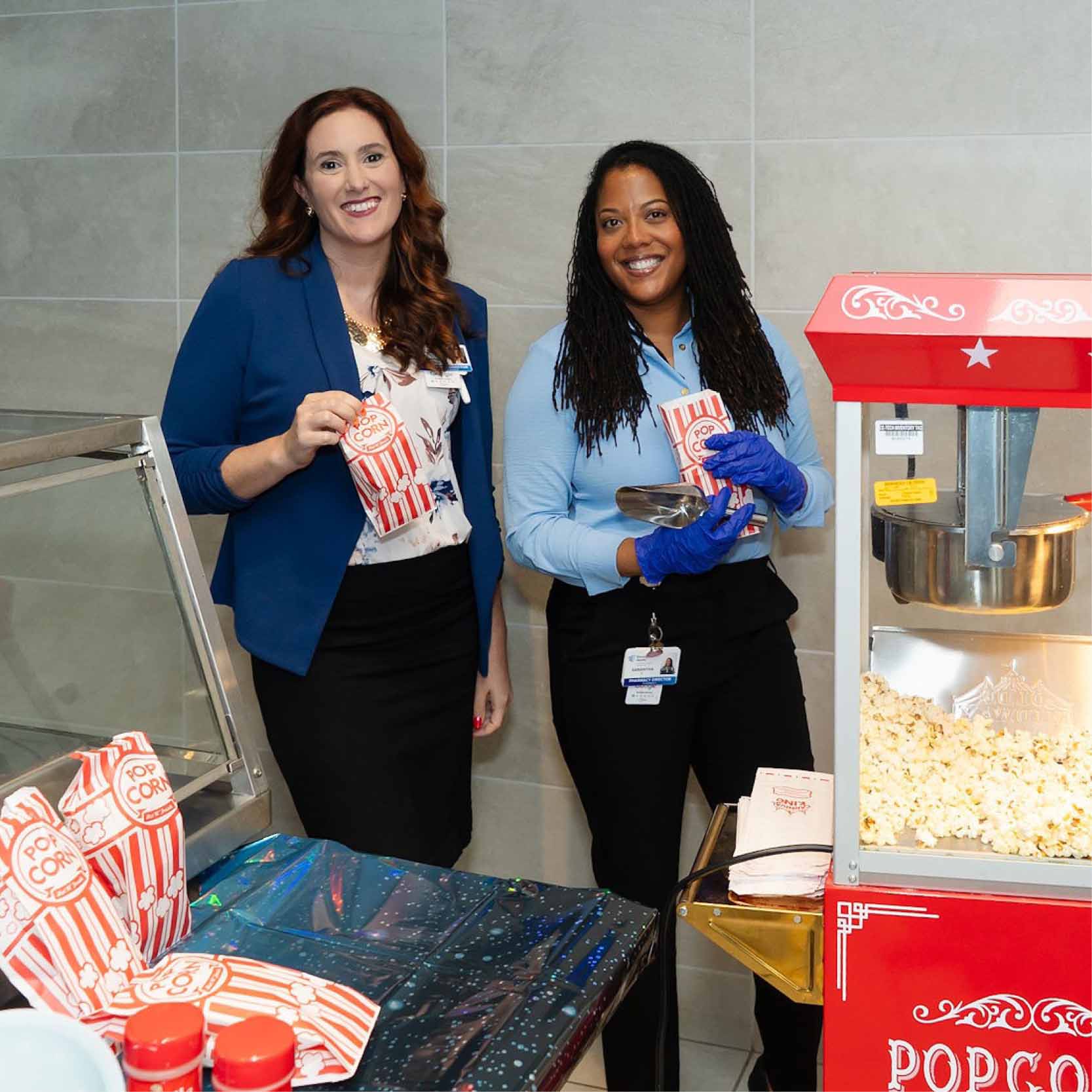 Two employees serving popcorn