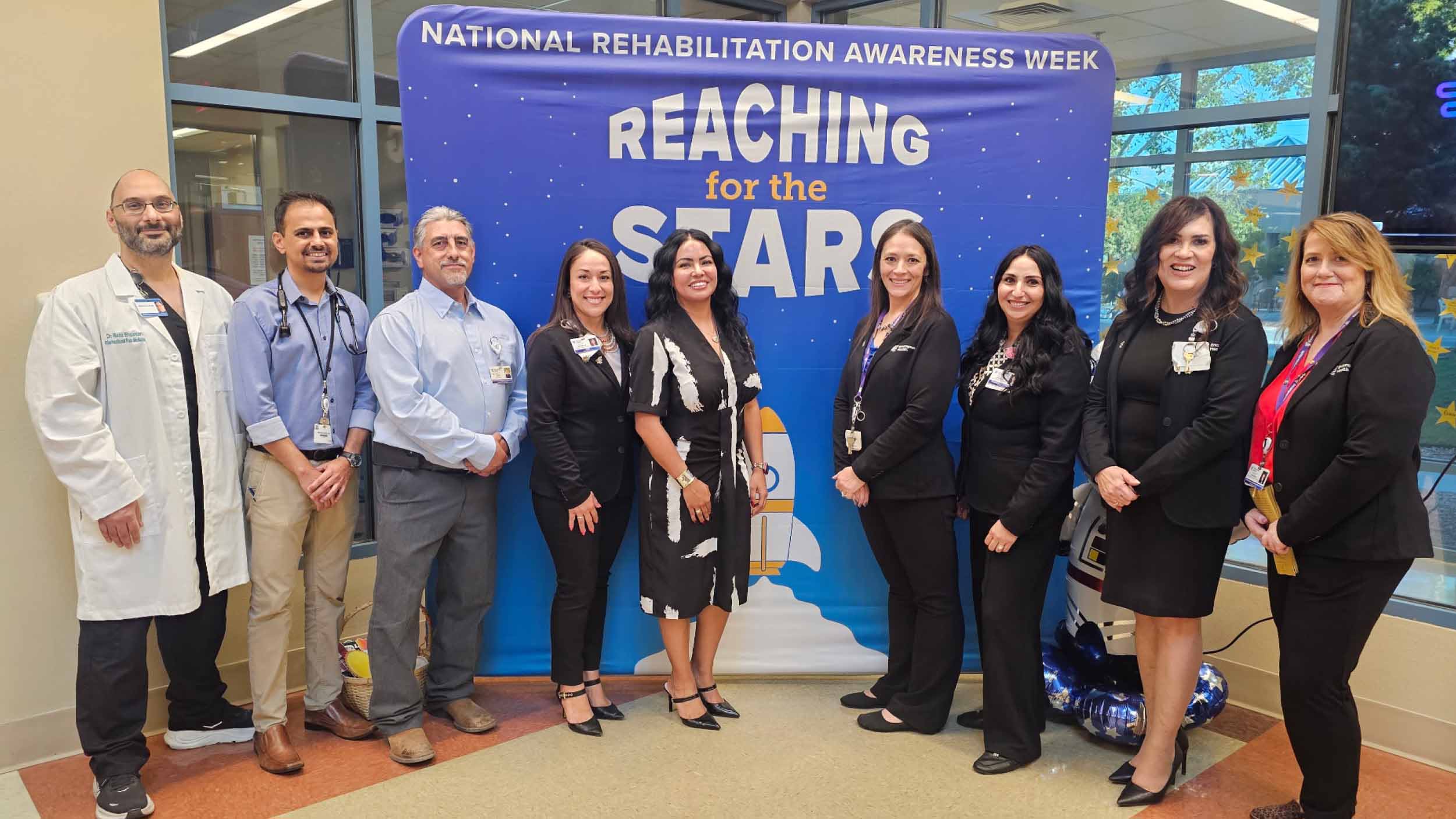 Group photo of Albuquerque staff in front of a banner