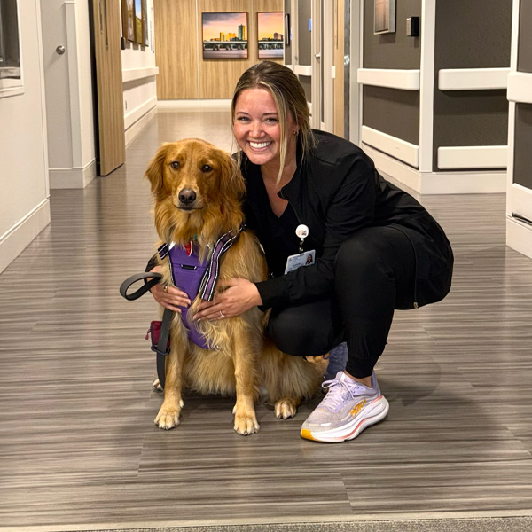 Ascension St. John Rehabilitation Hospital of Owasso therapy dog Molly posing with her trainer.