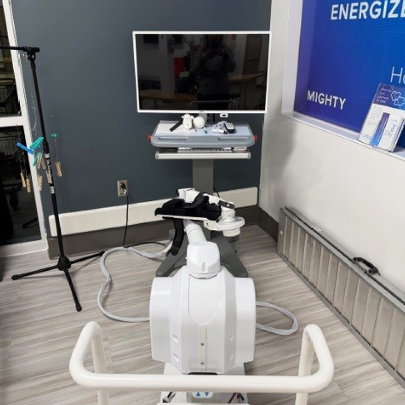 Close‑up of advanced therapy technology featuring a mounted monitor, control console, and connected rehabilitation device in the UVA therapy gym expansion.