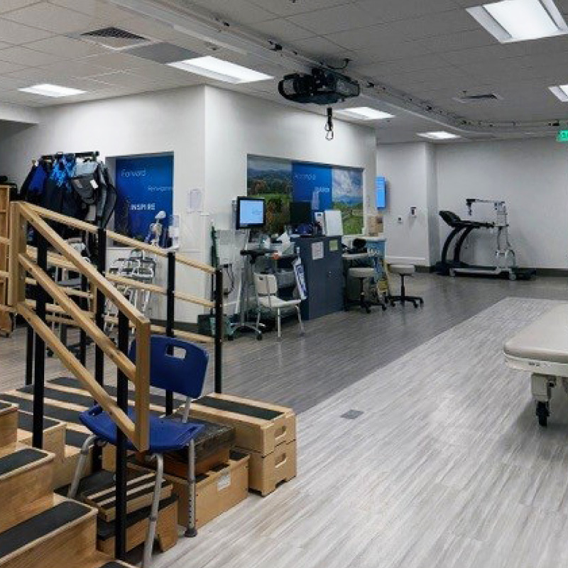 Expanded UVA therapy gym featuring therapy stairs, treatment tables, mobility equipment, and assistive devices arranged in a bright, modern rehabilitation space.