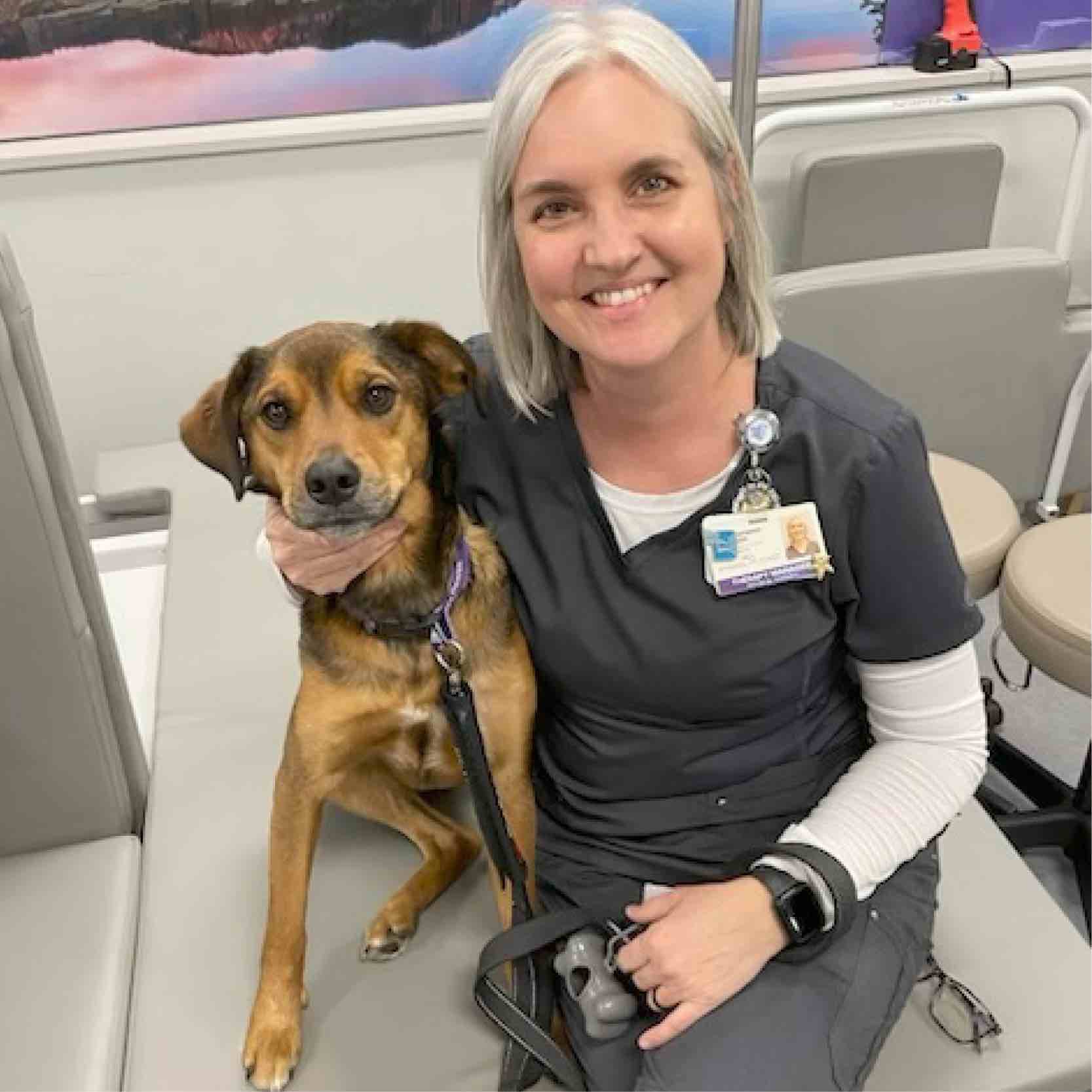 Staff member seated with a therapy dog at a Greenville rehabilitation hospital, showing pet therapy engagement that supports emotional well-being and recovery.