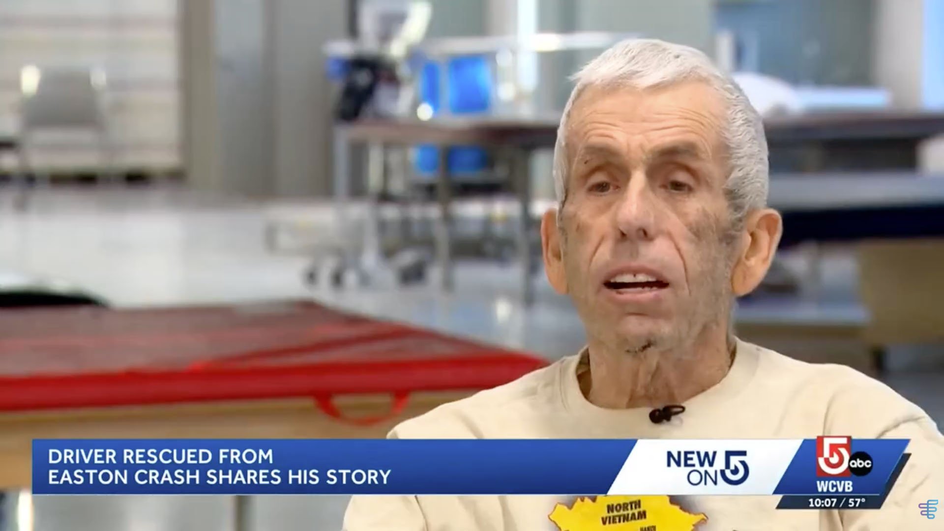 Elderly man speaking in an interview about a crash, wearing a beige shirt, appears focused. Text: "Driver rescued from Easton crash shares his story."
