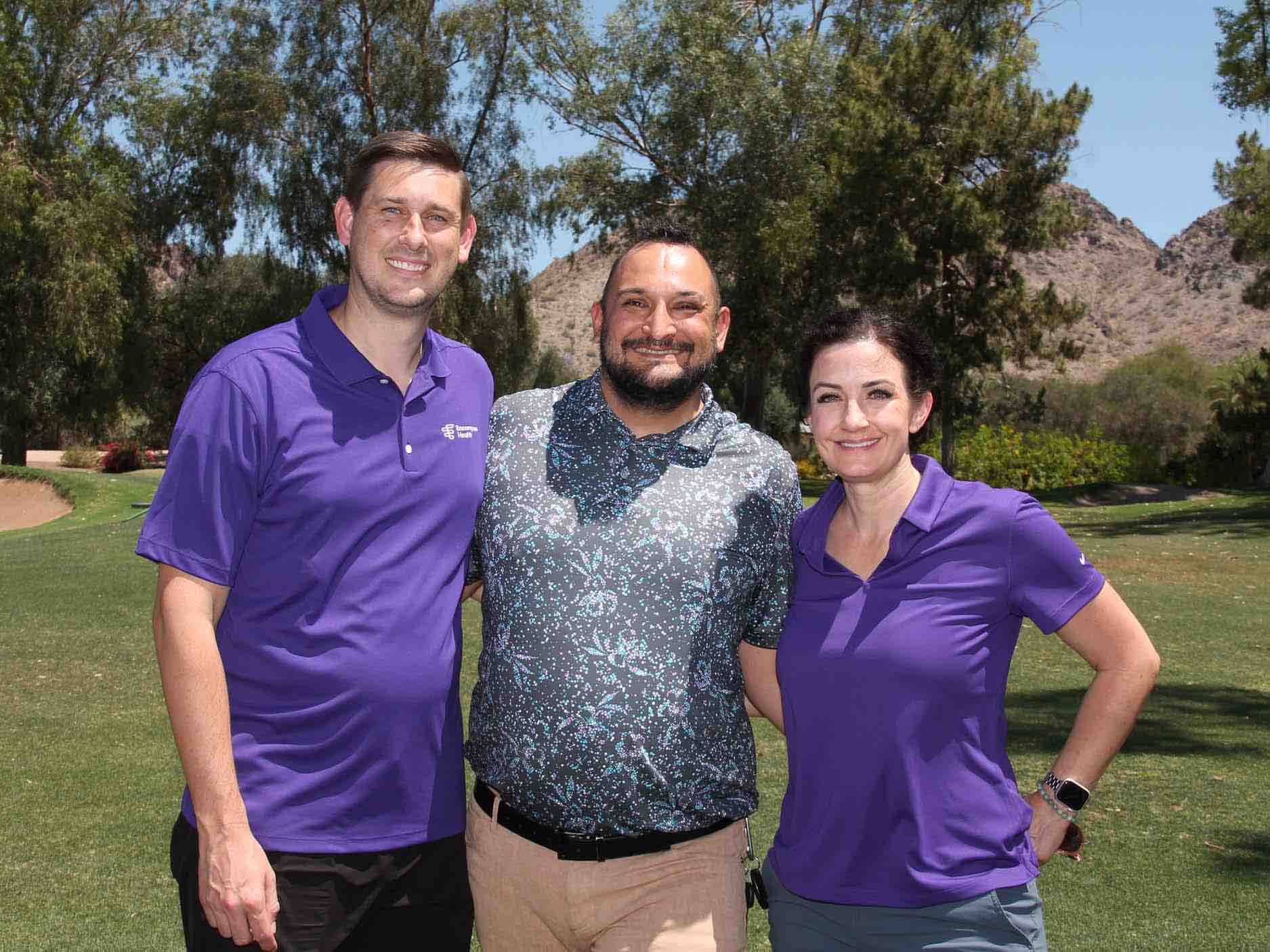 Three participants pose together on a golf course during a veterans charity tournament, highlighting community engagement and fundraising efforts that support rehabilitation services