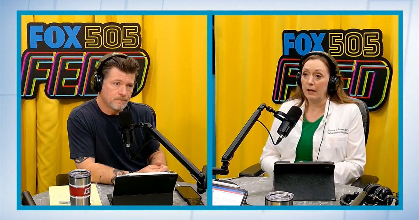 A split screen shows a podcast host and his guest in front of microphones. The man on the left wears a navy shirt, and the woman on the right, in a white coat, both wearing headphones.