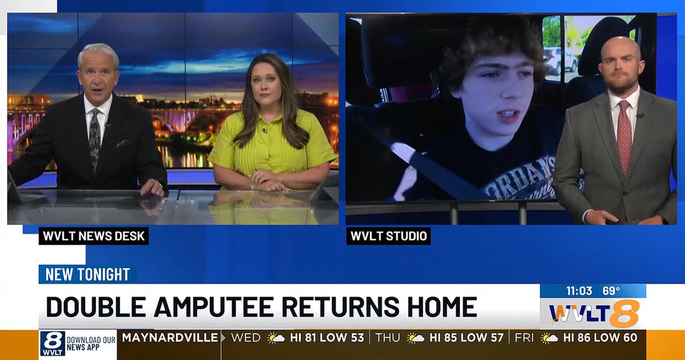 TV news screenshot showing two anchors at a desk, a person speaking remotely, and a third person in the studio. Headline: Double Amputee Returns Home.