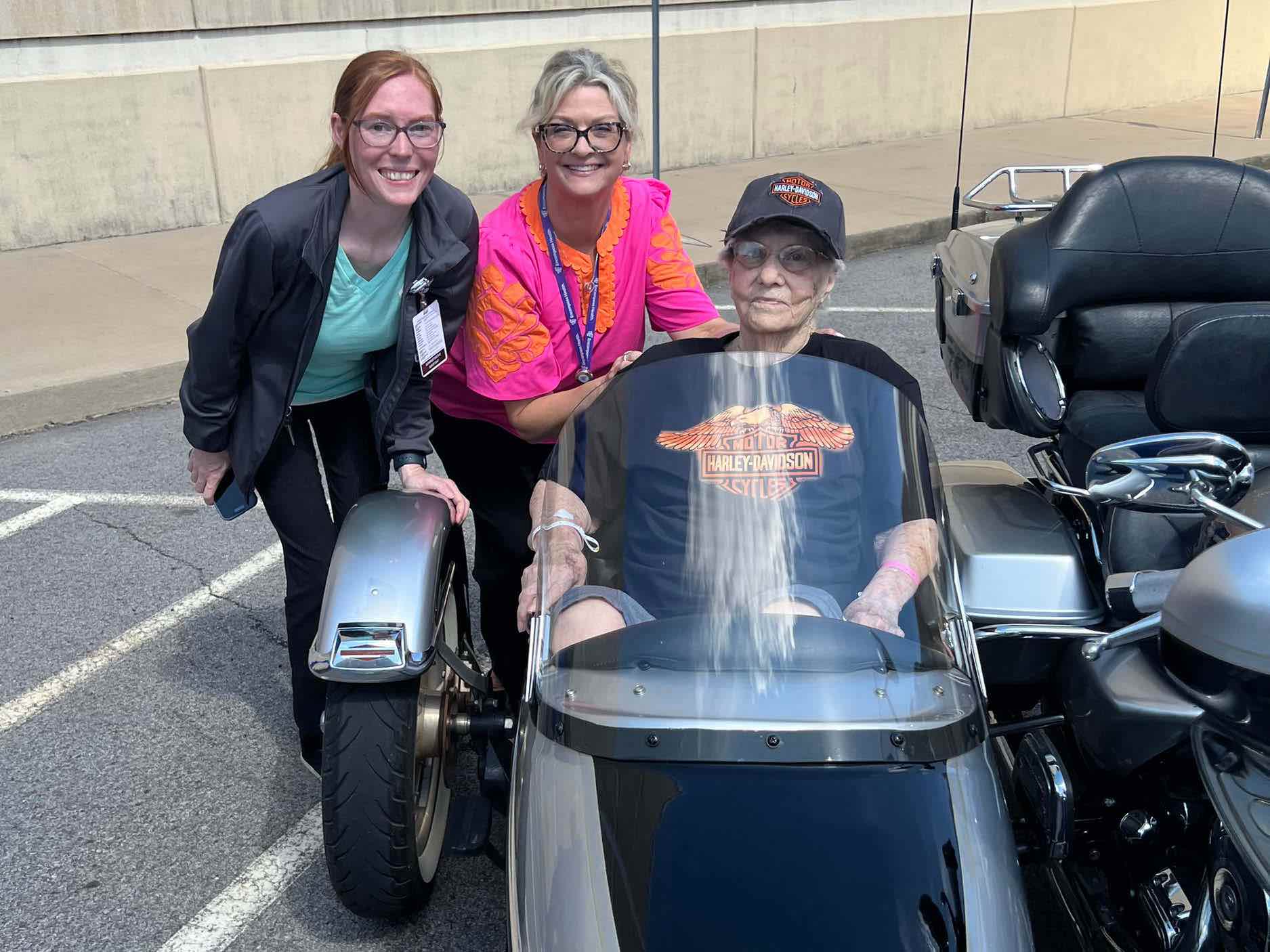 Rehabilitation hospital team members pose with a patient seated on a three-wheel motorcycle during a Stroke Smart community outreach event, highlighting recovery, mobility and engagement.