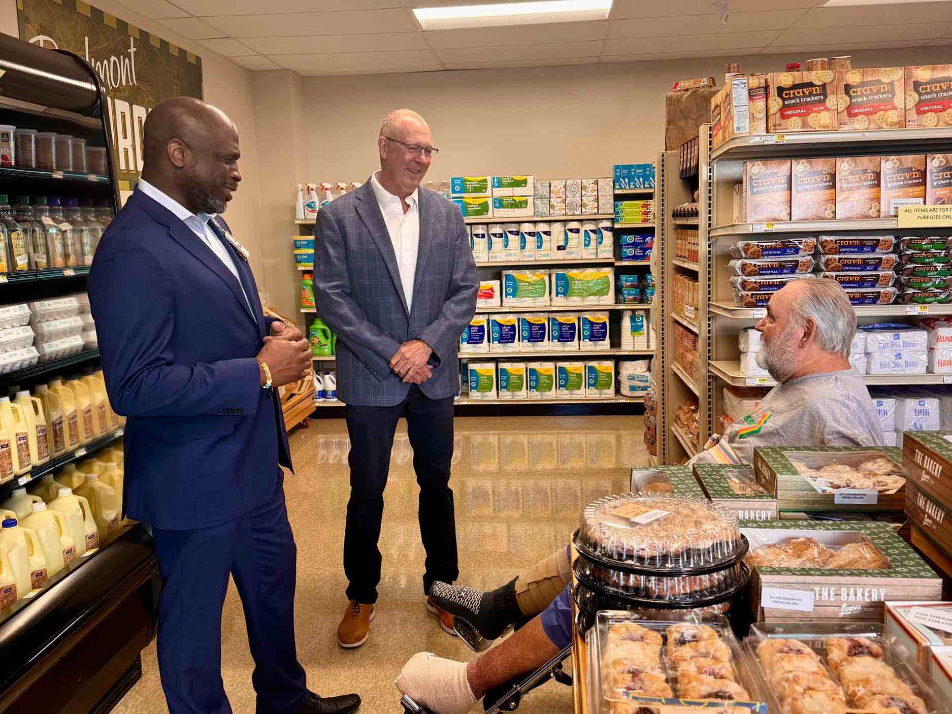 Rehabilitation hospital representatives speak with a former patient inside the grocery store simulator, highlighting practical stroke recovery therapy focused on community reintegration skills.