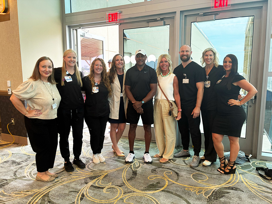 Group photo of community members and healthcare employees at an indoor event venue.