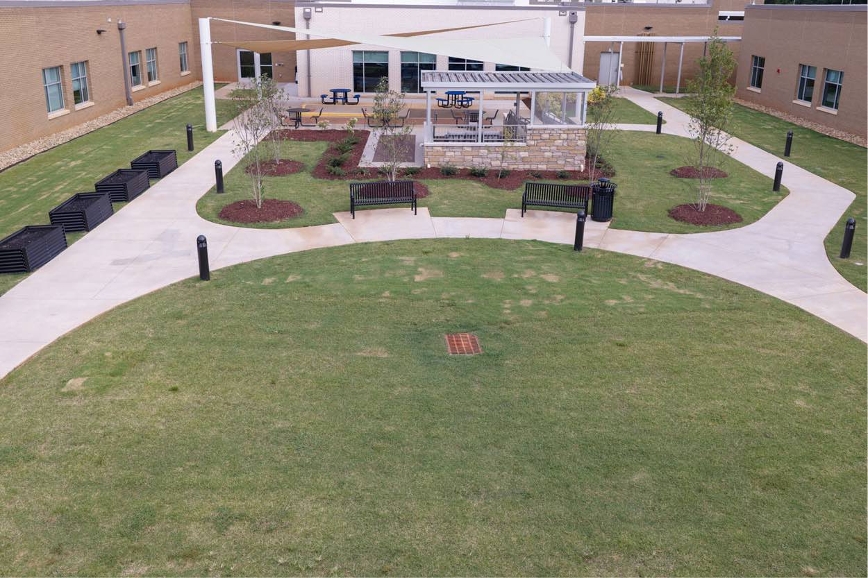 Outdoor courtyard at Encompass Health Greenville following a bed expansion, featuring seating and therapy spaces.