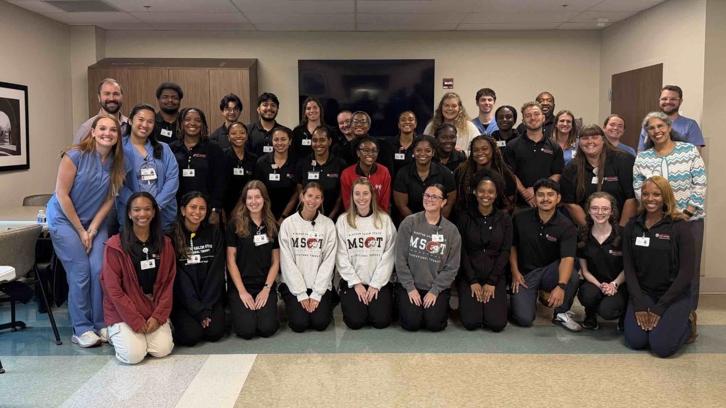 Winston-Salem State University occupational therapy students and rehabilitation professionals gather for a group photo during an educational visit to an inpatient rehabilitation hospital.
