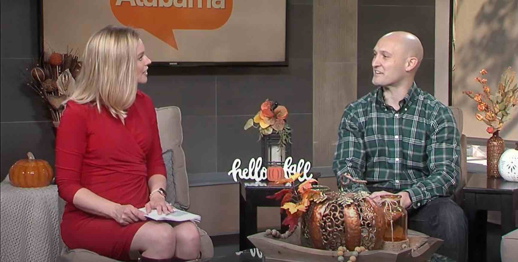 Fall‑themed studio interview featuring two individuals seated near seasonal decorations, including pumpkins and autumn floral arrangements, discussing community health topics.