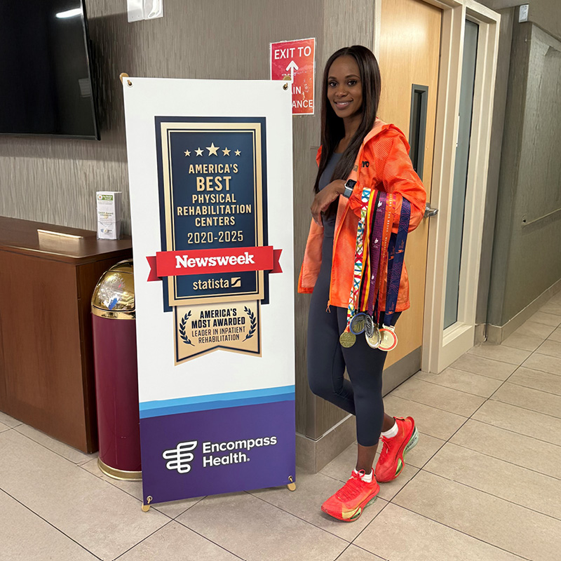 Marion Jones standing in front of a banner for the Newsweek award of 2025