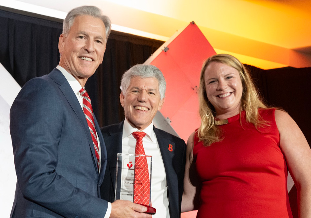 Encompass Health President and CEO Mark Tarr receiving an award, pictured with Encompass Health Vice President of Operations Support Elaine Prince and AHA National Board Chair Lee Shapiro.