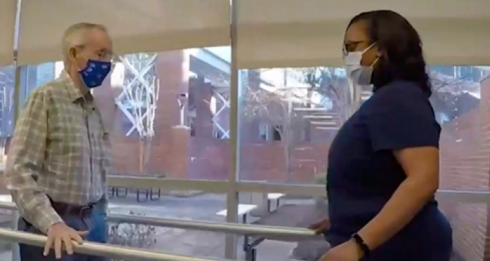 Martin working with physical therapist to rebuild his strength in the therapy gym at Encompass Health Memphis