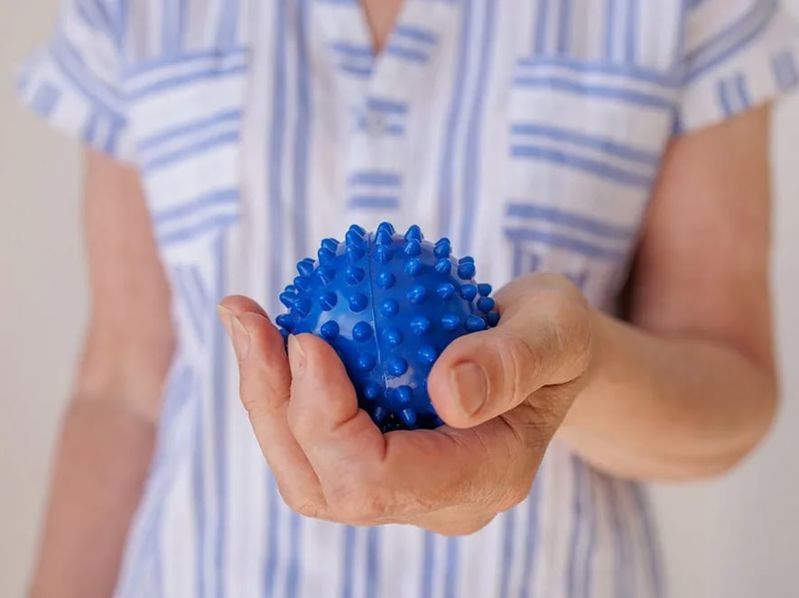 A blue ball in left hand for movement exercises