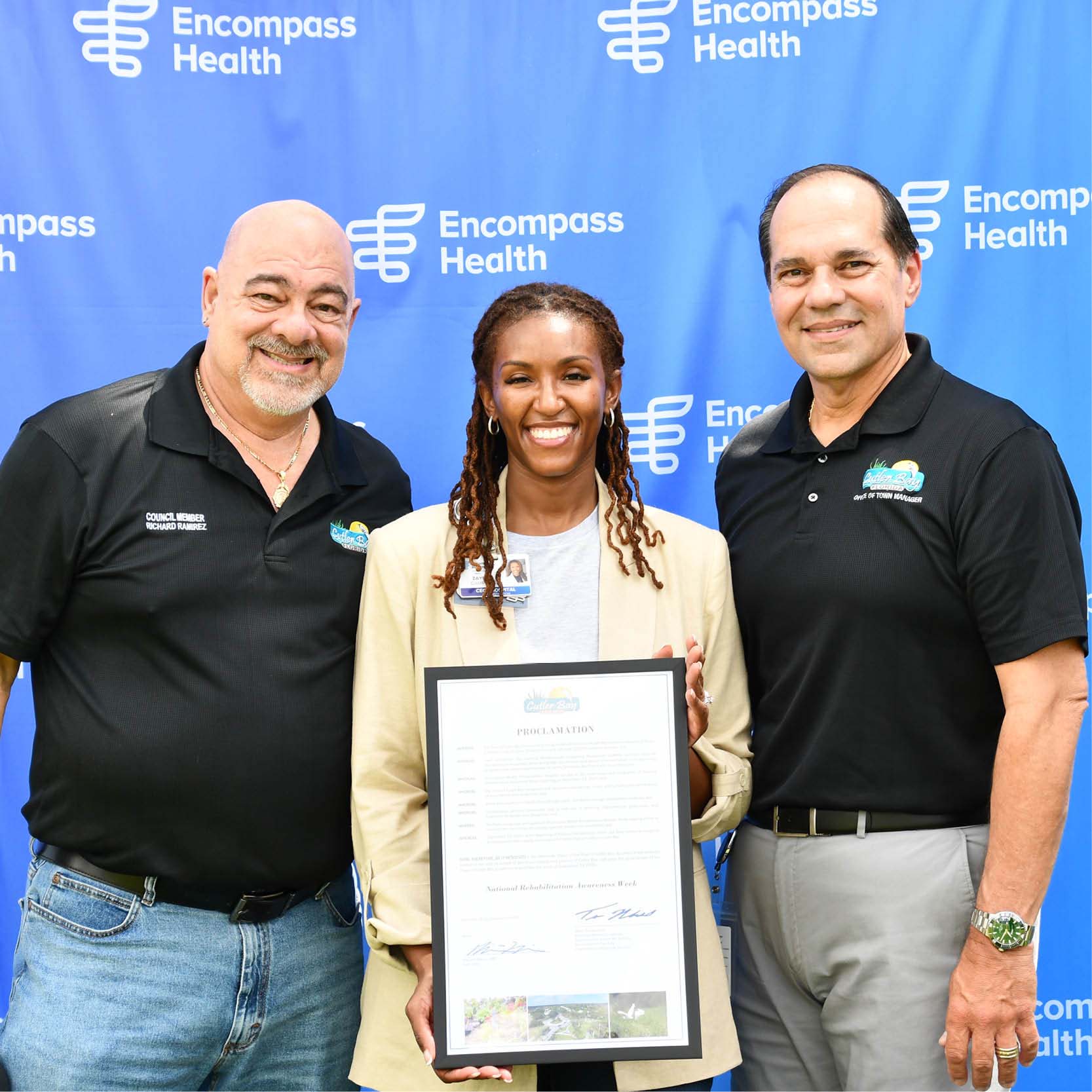 Three people smiling in front of an 