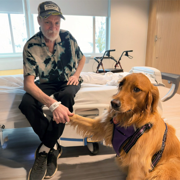 Ascension St. John Rehabilitation Hospital of Owasso therapy dog Molly shaking hands with a patient.