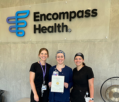Three Encompass Health Fitchburg nurses holding a TJC Accreditation certificate