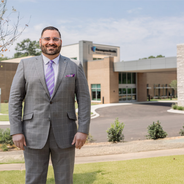 Encompass Health Greenville CEO Joshua Trout standing in front of the hospital