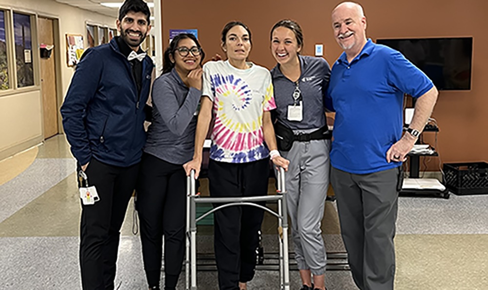 Valerie, a patient with Atypical Guillain-Barré, with her Encompass Health therapists