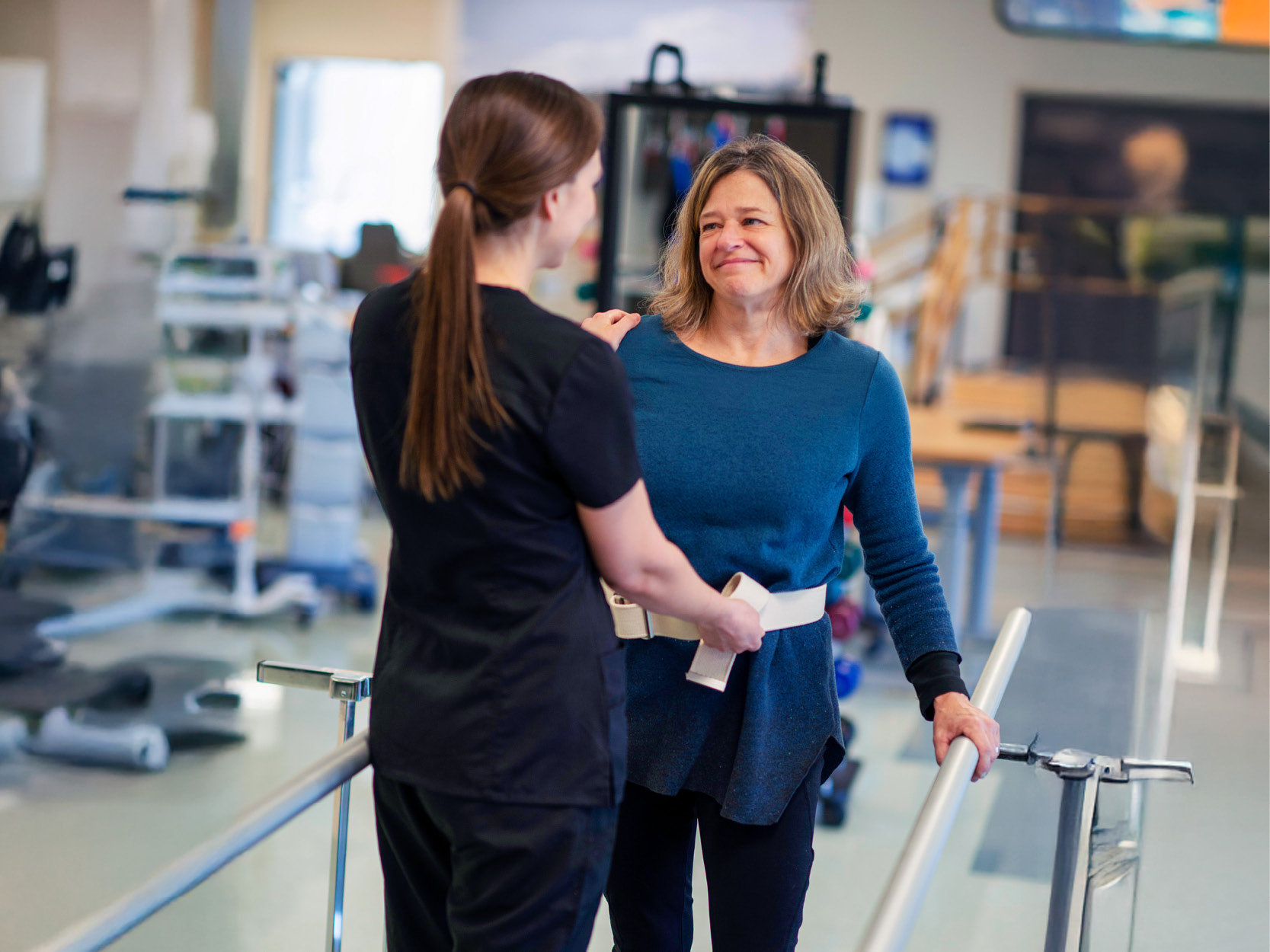 patient on the parallel bars with a physical therapist
