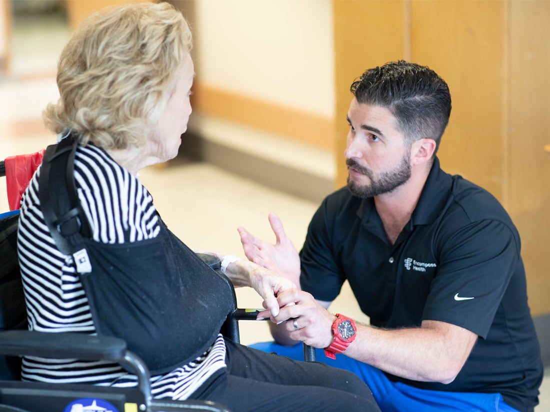 Therapist speaking with a patient in a wheelchair