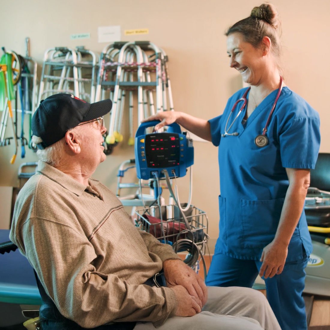 A nurse speaking with a patient sitting in a wheelchair