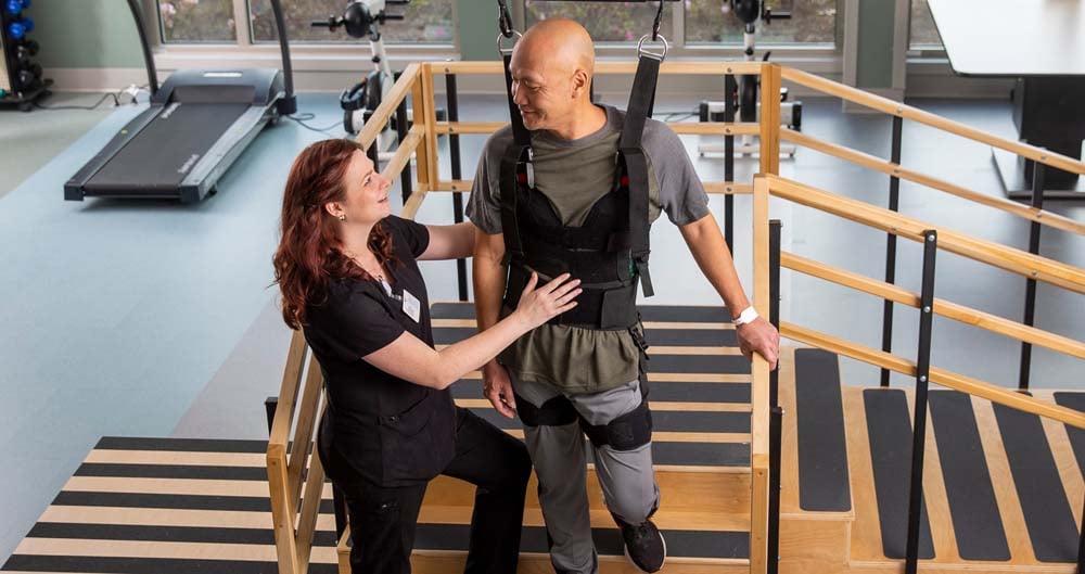 Patient being assisted by a physical therapist down steps