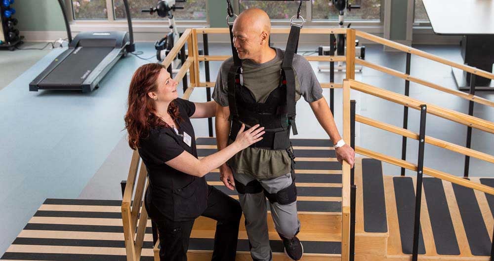 Patient being assisted by a physical therapist down steps