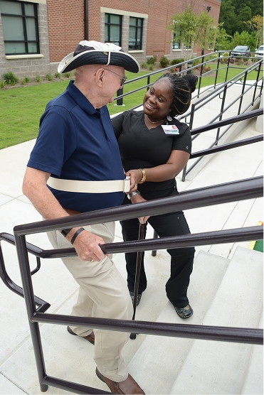 Veteran practices stair navigation with therapist guidance during inpatient rehabilitation and recovery.