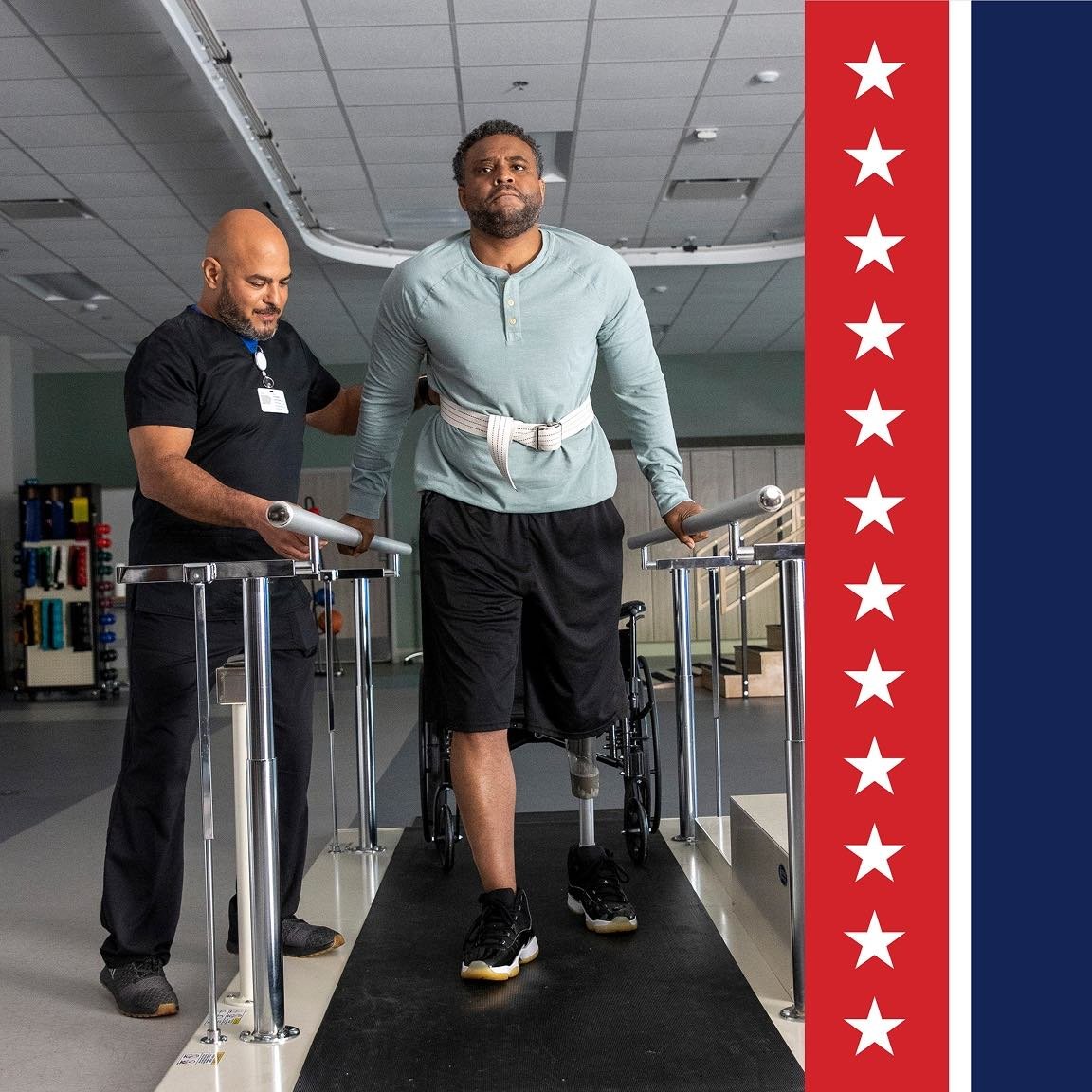Veteran with lower-limb amputation participates in rehabilitation gait training between parallel bars while a therapist provides support, promoting strength, balance, mobility, and independence recovery