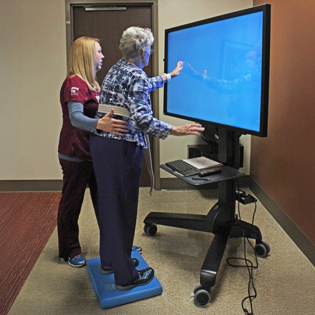 A therapy nurse helping a patient use the Bioness B.I.T.S. Balance system