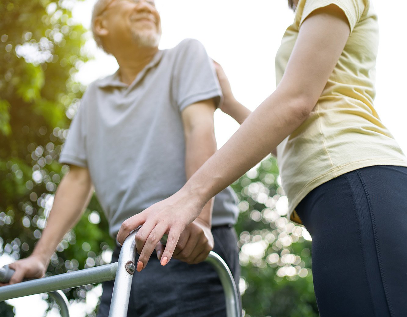 Woman helping a man who is using a walker