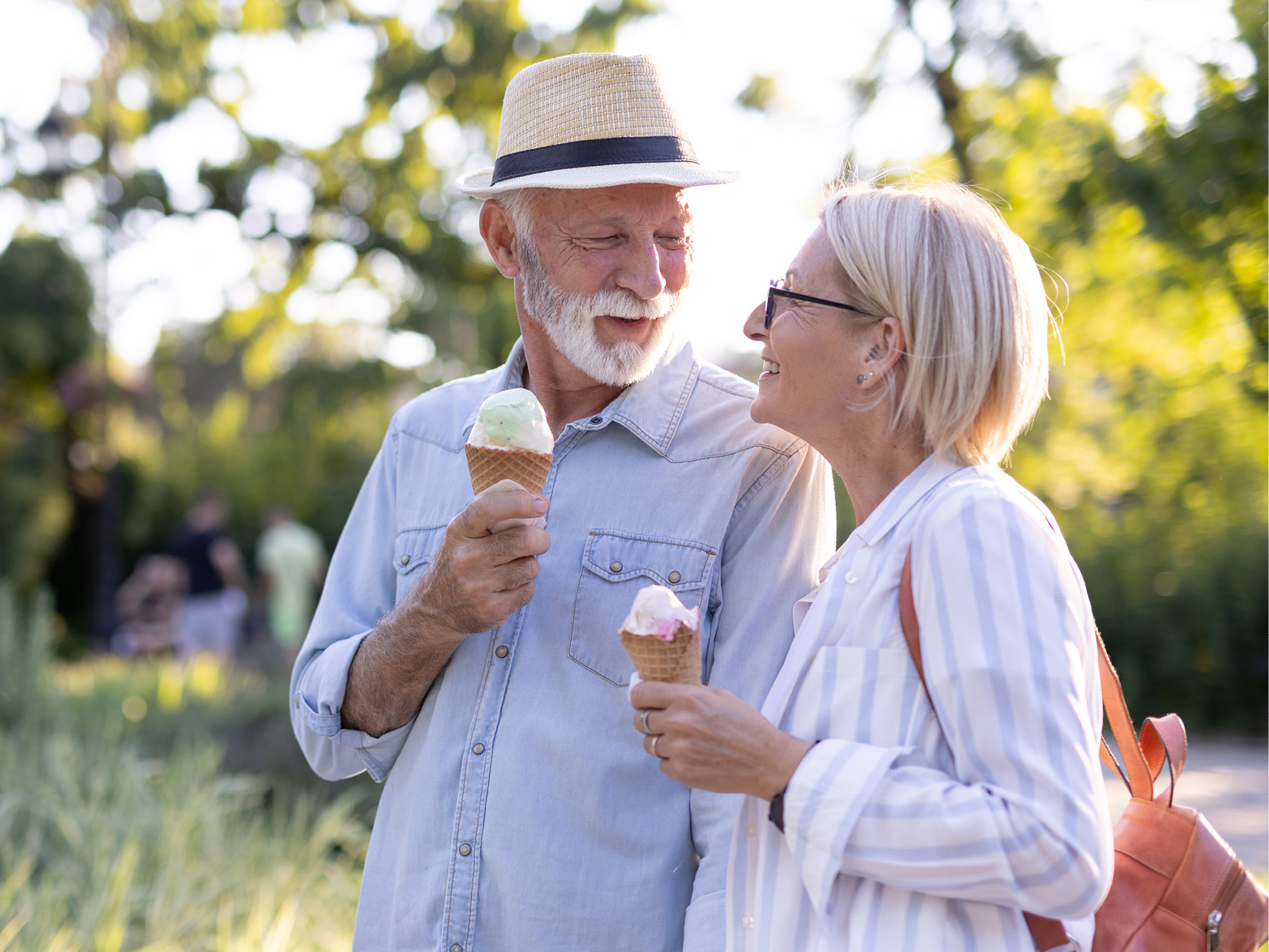 a couple walking in the park with ice cream