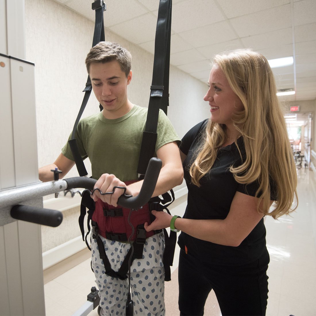 Patient using a Litegait device while a therapist assists him