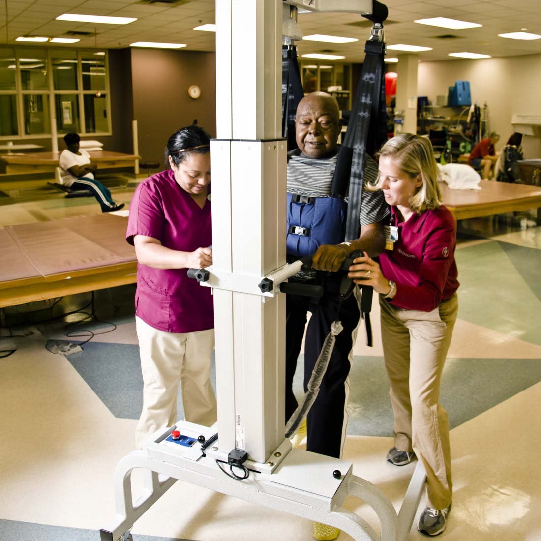 Two therapists helping a patient use a LiteGait device
