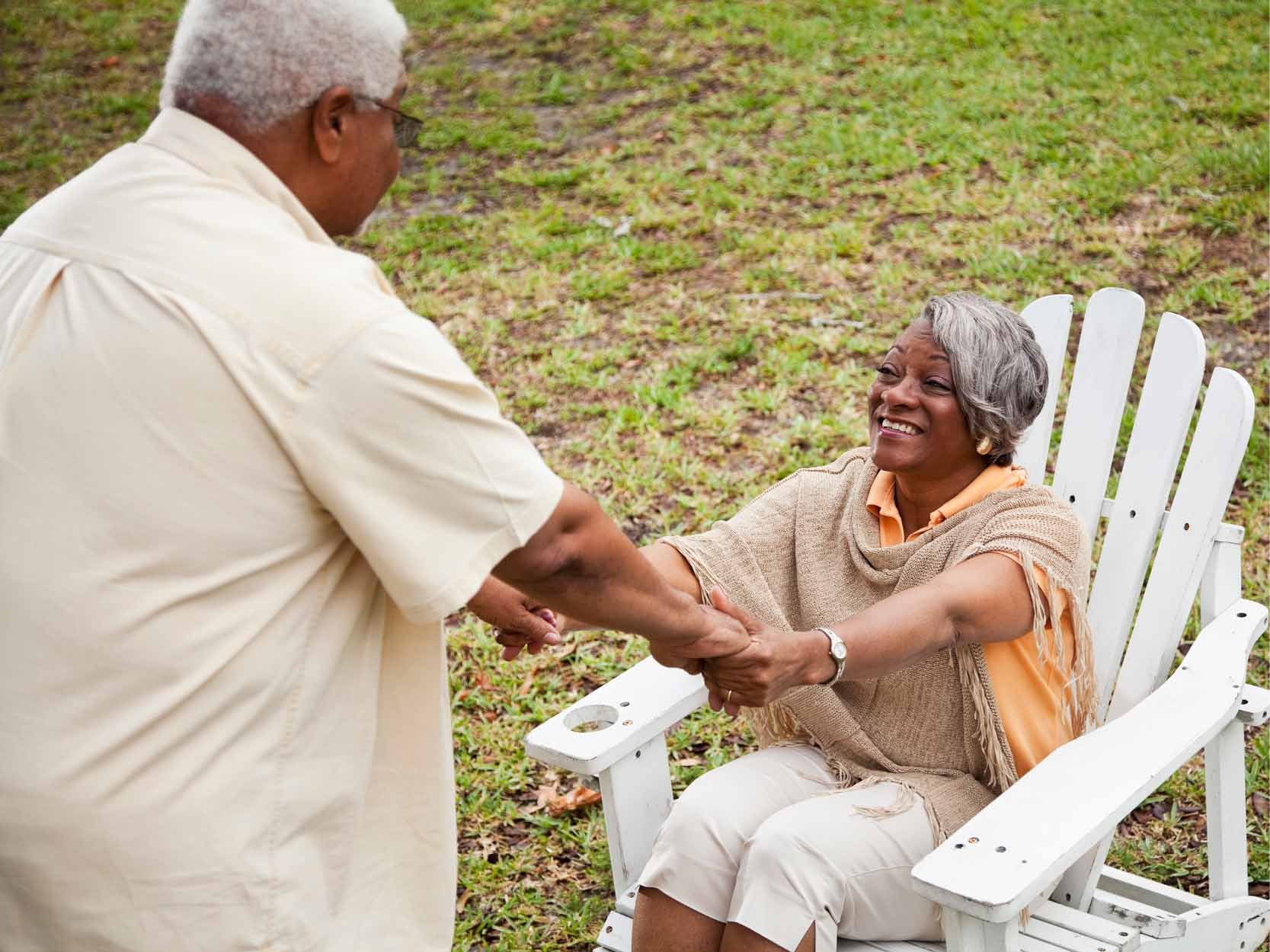man and woman holding hands and about to stand