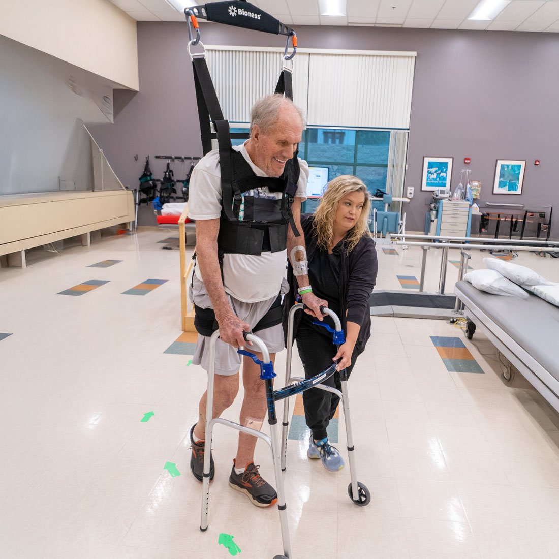 Patient using a Bioness Vector system with a walker