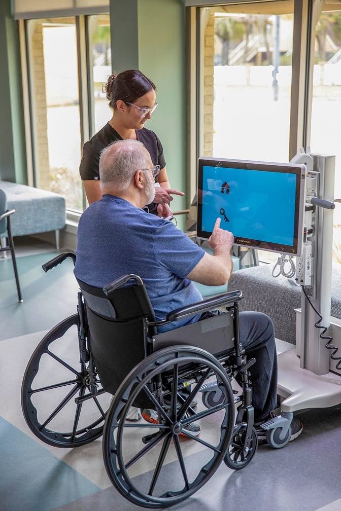 Patient participates in neurological therapy using interactive technology with a therapist during inpatient rehabilitation.