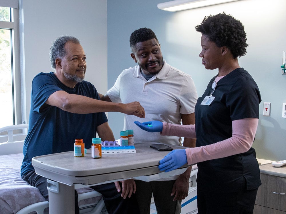 A patient receiving pills from his nurse