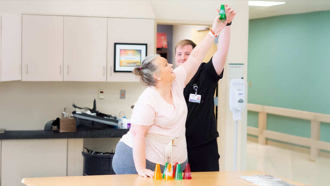 Therapy nurse helping a patient reach