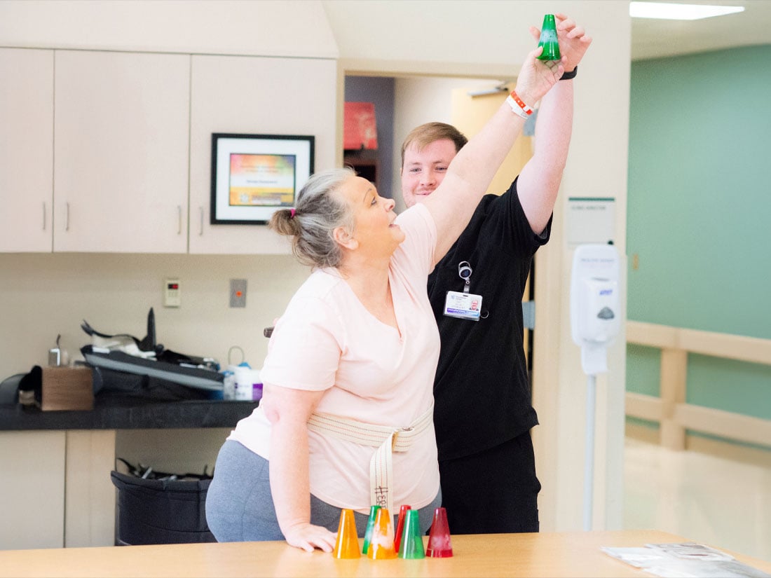 Therapy nurse helping a patient reach