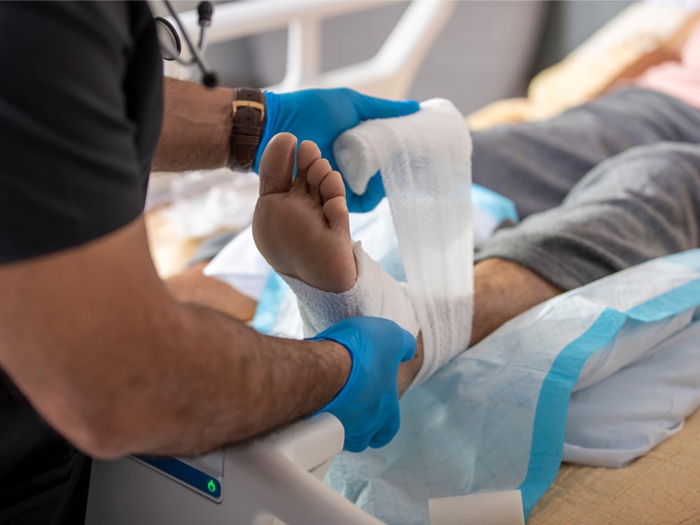 A nurse wrapping a patient's foot