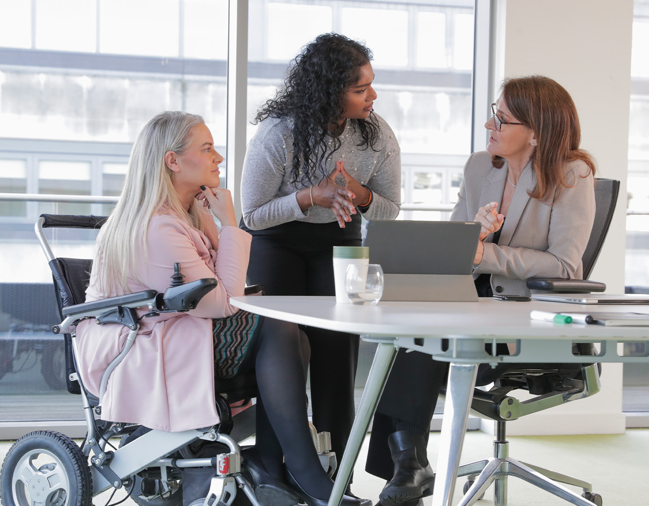 Employees consulting over a laptop