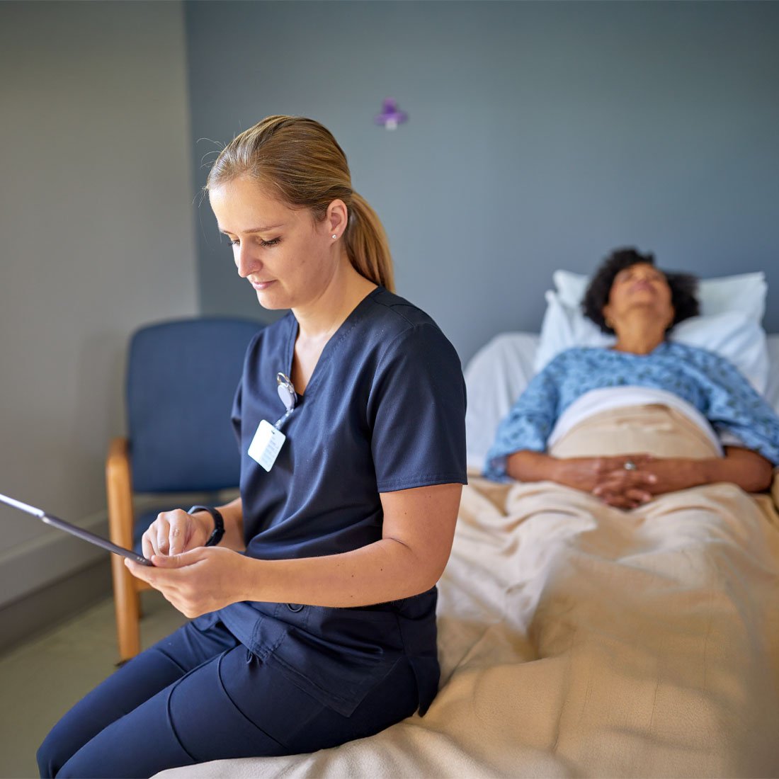 Case manager on a tablet sitting next to a patient